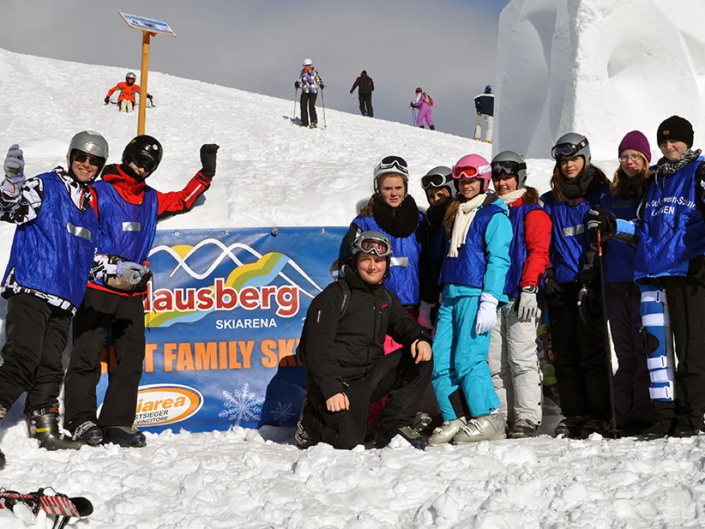 Gruppenfoto vor dem Schild des Skigebiets Klausberg.